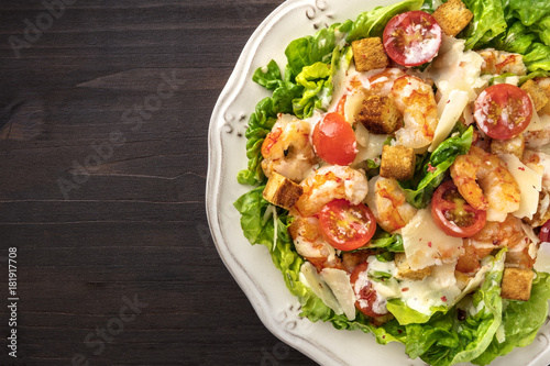 Overhead closeup photo of shrimp Caesar salad with copyspace