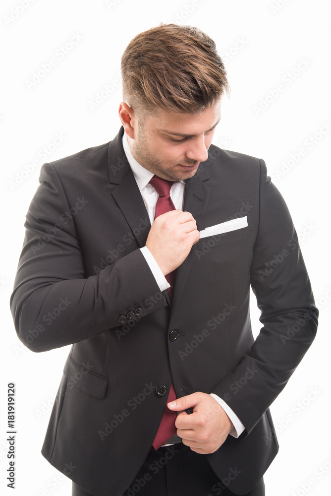 Handsome business man standing arranging his jacket Handsome business man standing arranging his jacket