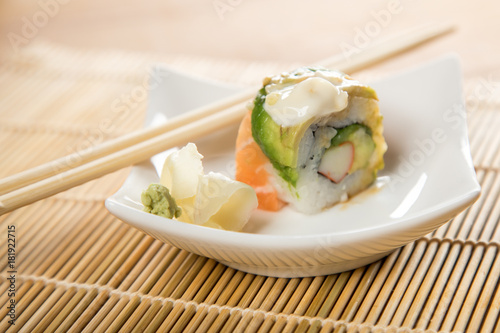 California Sushi Rolle mit Surimi und Topping aus Lachs, Avocado und Mayo Creme Soße