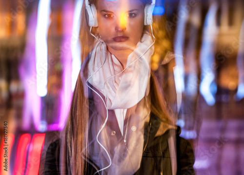 Woman in city at night among neon moving lights, fashion portrait
