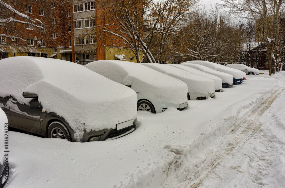 Cars covered with fresh white snow on city parking lot