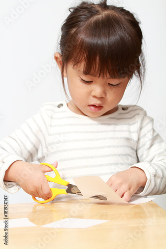 はさみで紙を切る幼児(3歳児)