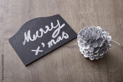 merry christmas text sign with pine cone ornament