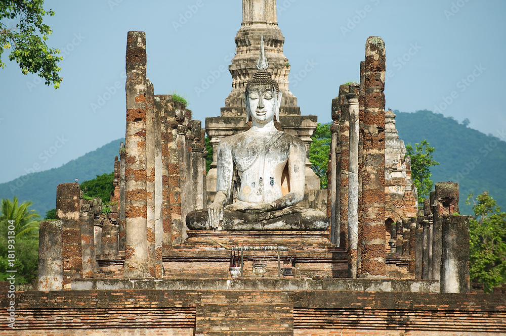 Sitting Buddha statue at the ruins of the main chapel of the Wat Mahathat temple in Sukhotai Historical Park, Thailand.