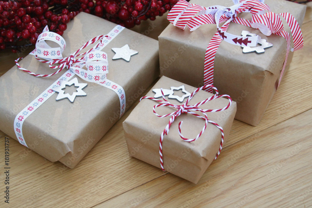 Foto Stock Pacchi regalo natalizi con fiocchi e decorazioni su tavolo di  legno. Sfondo di Natale