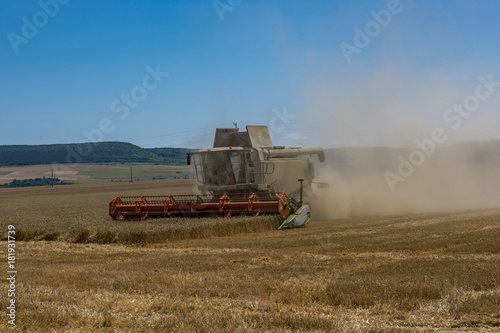 Close-up of a working harvester's back at harvest time. A dust and straw fertilizer. Concept farming and agriculture.