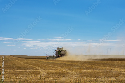 Close-up of a working harvester's back at harvest time. A dust and straw fertilizer. Concept farming and agriculture. © Ganka