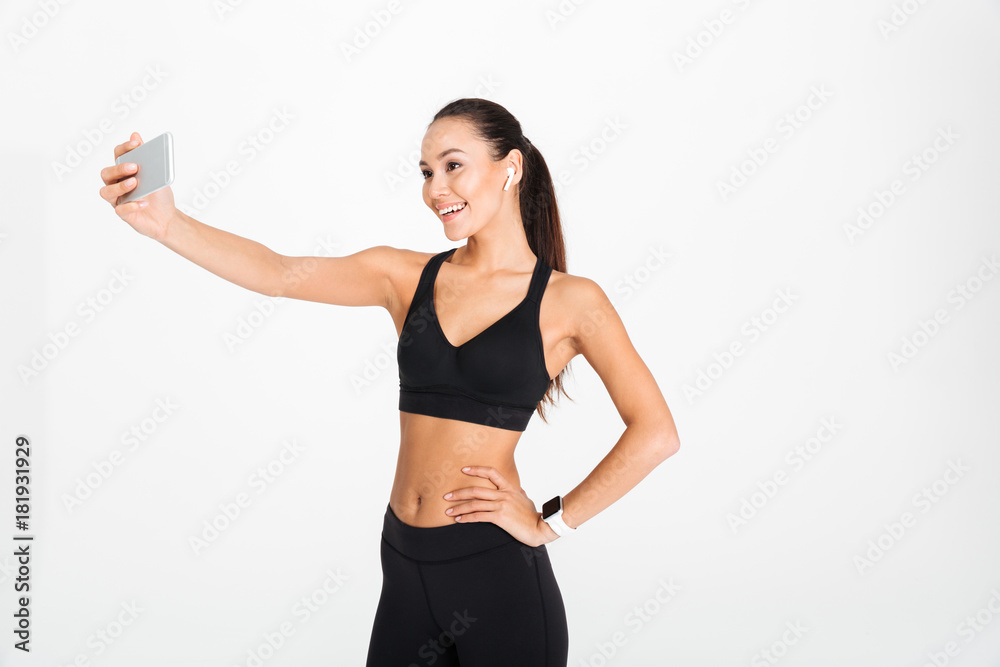 Portrait of a smiling asian fitness woman in earphones Portrait of a smiling asian fitness woman in earphones