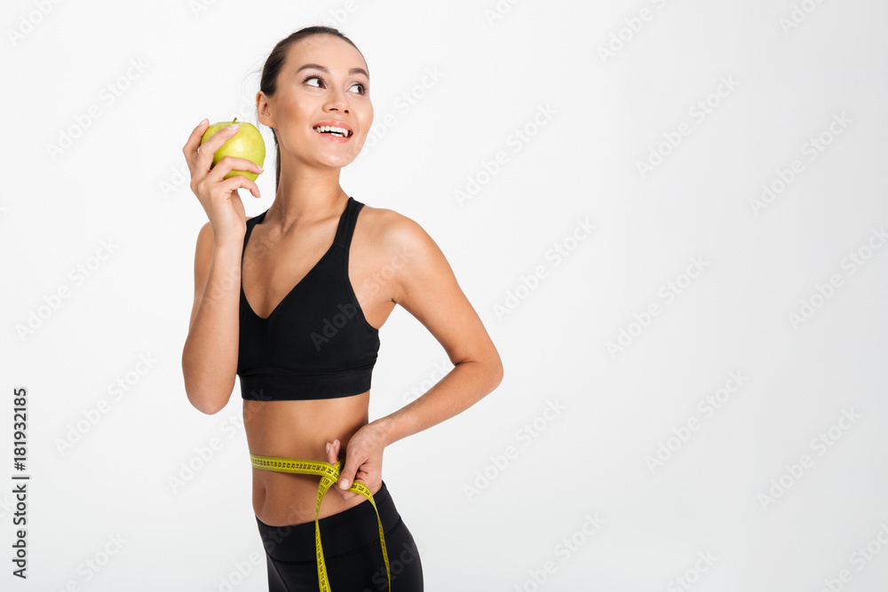 Portrait of a slim asian fitness woman holding apple