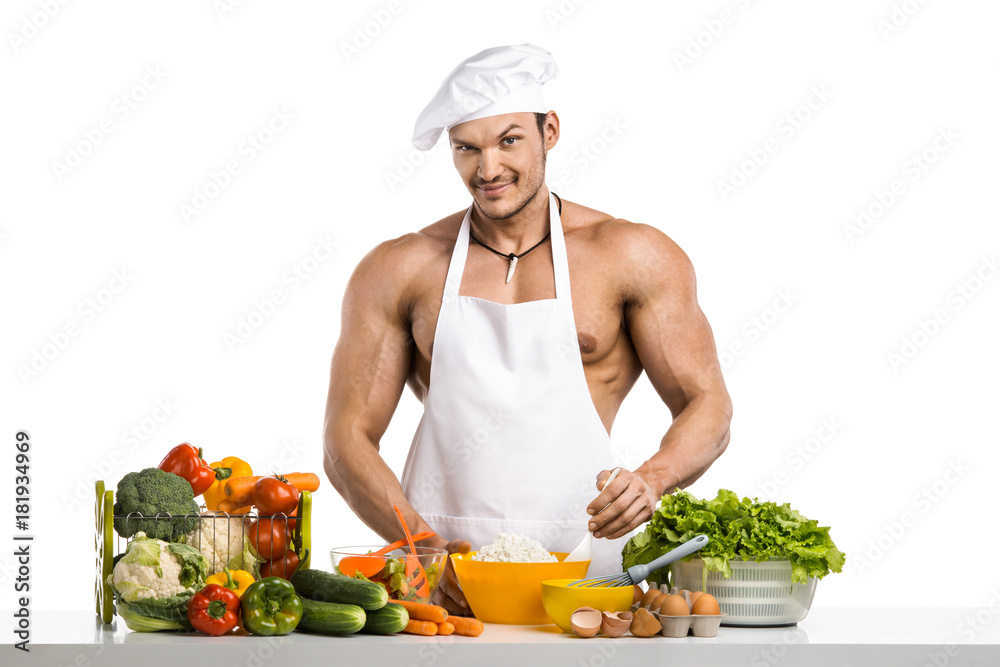 Man bodybuilder in white toque blanche and cook protective apron cooking cottage cheese and vegetables Man bodybuilder in white toque blanche and cook protective apron cooking cottage cheese and vegetables