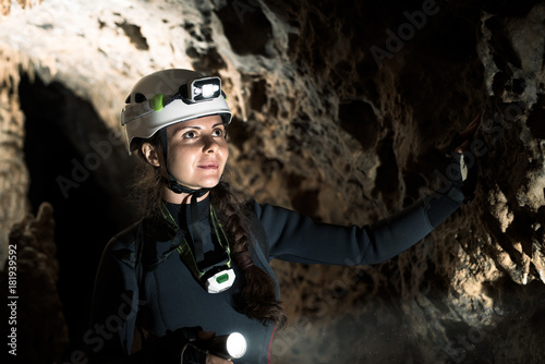 A speleologist is exploring a cave, Punta degli Stretti Cave, Tuscany, Italy - The excitement of the discovering shines in her wonderful eyes! photo