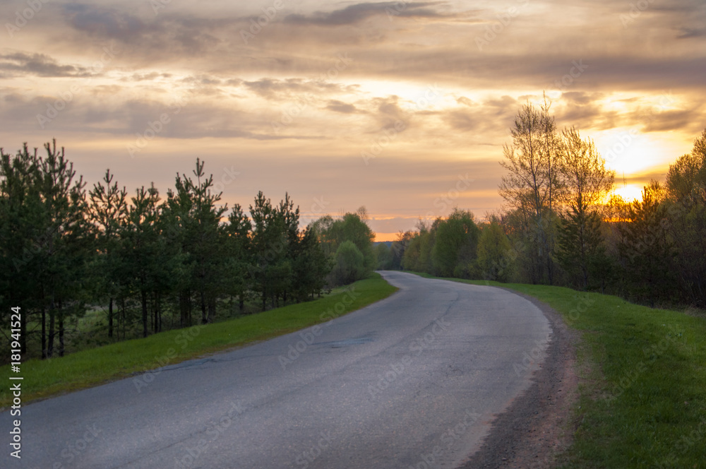 Spring landscape, sunrise sunrise. A country road, a rural landscape with a road.