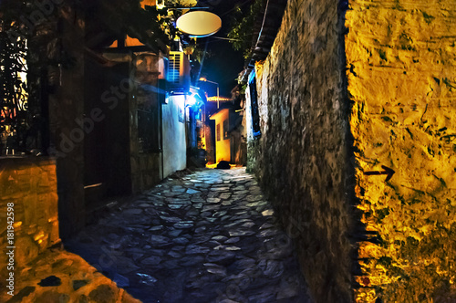 Obraz na plátne Illuminated cobbled street in old city by night