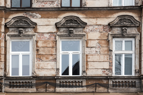 Three Windows on the facade of the old shabby house