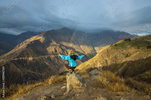 Young woman meditate above the deepest canyon Colca. Panoramic breathtaking view of peruvian village and canyon Colca , Peru, South America photo