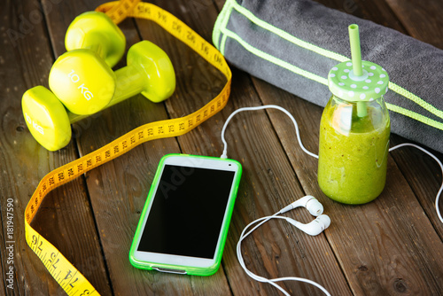 Smartphone and detox smoothie for fitness workout app or diet concept