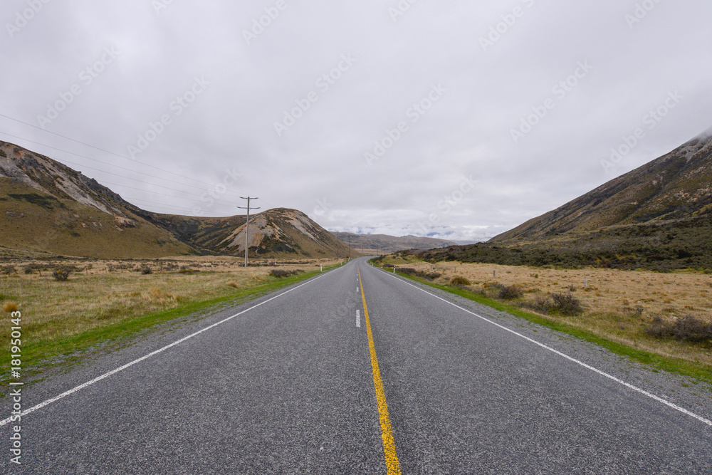 Road heading into the valley with fog in Arthur's Pass New Zealand