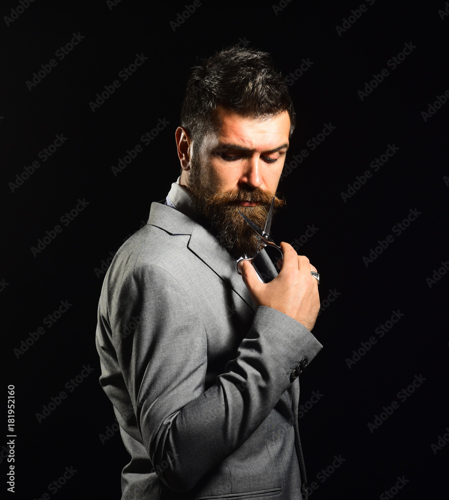 Man with beard holds steel scissors. Business and barbershop service Man with beard holds steel scissors. Business and barbershop service