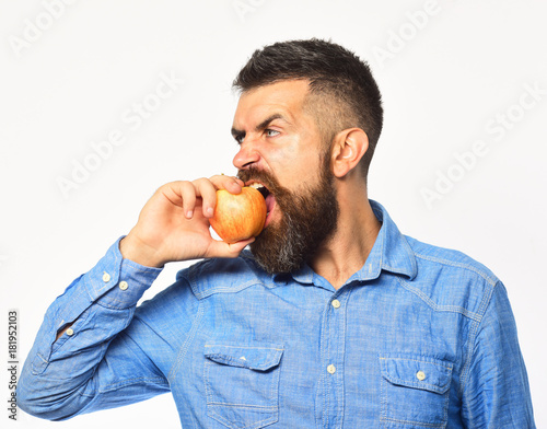 Farmer with hungry face eats apple. Guy presents homegrown harvest.