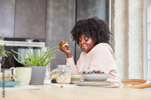 Plus Size Frau isst Apfel zum Frühstück