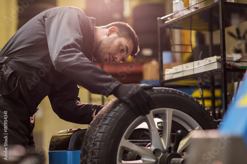 Konstfotografi auto mechanic balancing car wheel at workshop