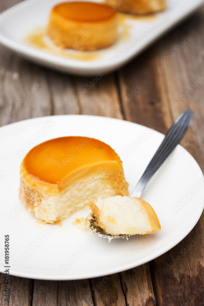 Homemade caramel custard cake in spoon. Served on white plate. Sweet dessert. Homemade caramel custard cake in spoon. Served on white plate. Sweet dessert.