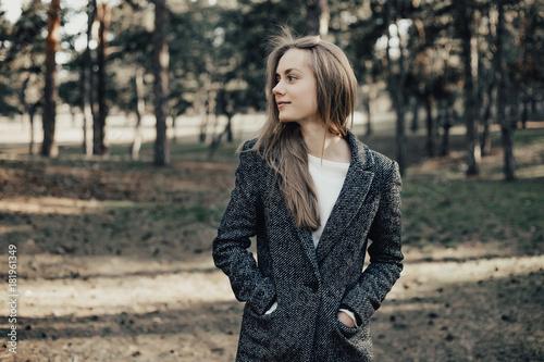 Confident woman looking sideways on the trees background outdoor © darakaliton