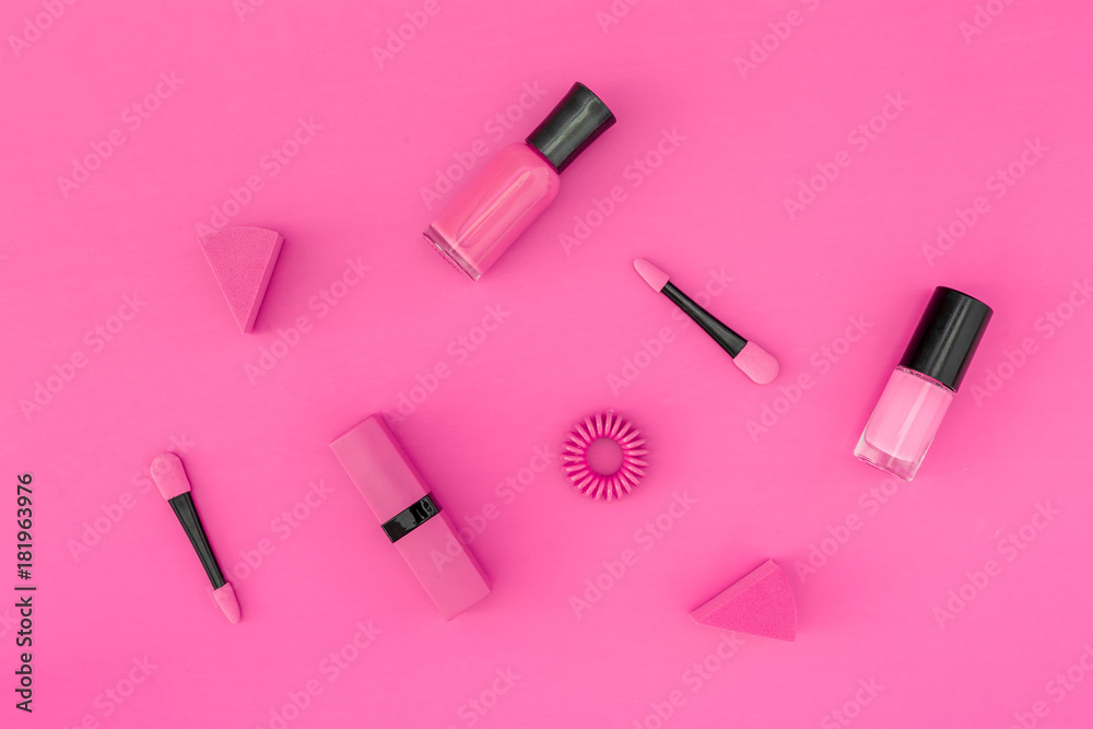 Bright decorative cosmetics. Pink nail polish and lipstick on pink background top view copyspace Bright decorative cosmetics. Pink nail polish and lipstick on pink background top view copyspace