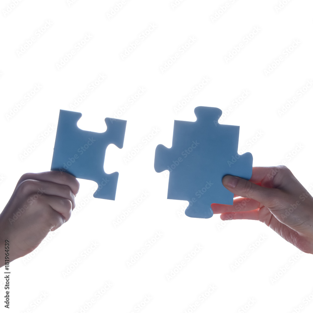 Silhouette of two hand holding couple of blue jigsaw puzzle piece on white background. concept - connection idea, sign, symbol, friendship, decision, success Silhouette of two hand holding couple of blue jigsaw puzzle piece on white background. concept - connection idea, sign, symbol, friendship, decision, success