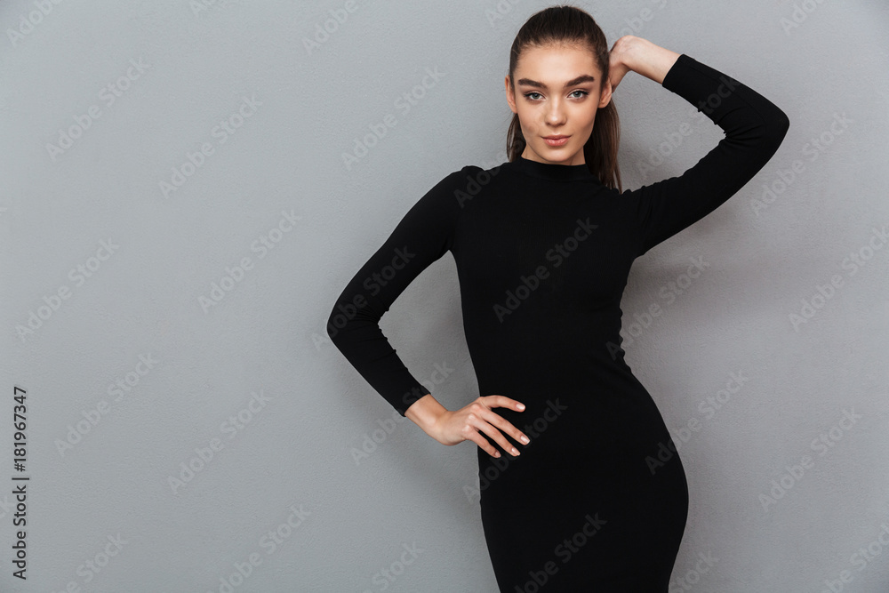 Obraz premium Portret pięknej uśmiechniętej kobiety w czarnej sukni pozowanie