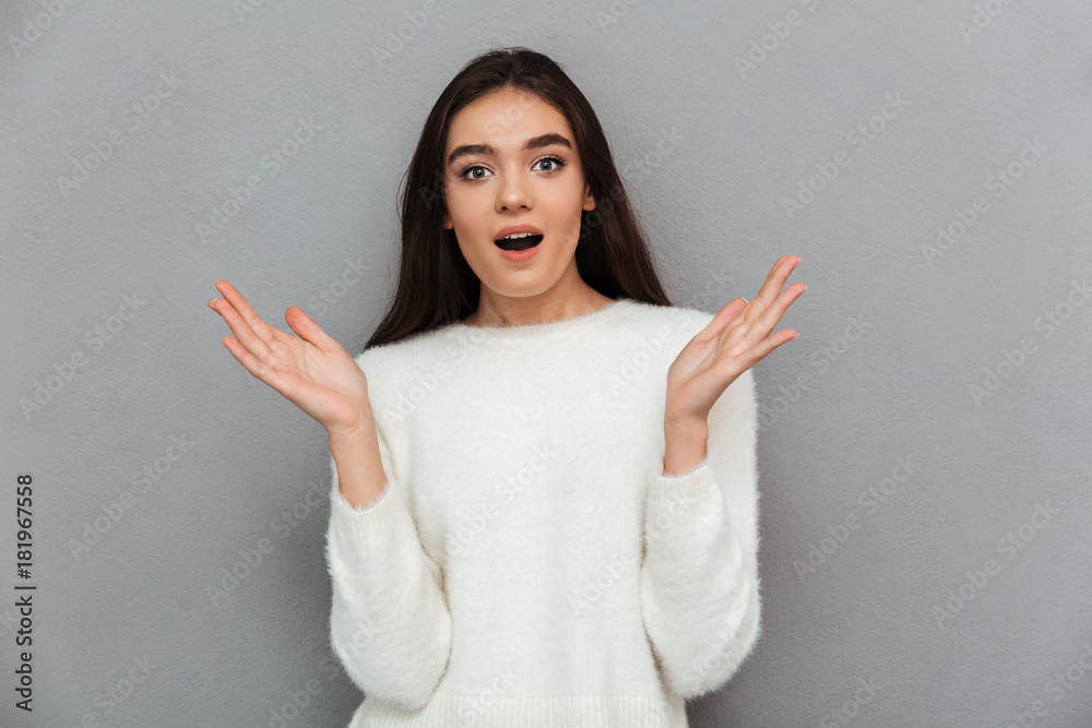 Close-up portrait of surprised beautiful brunette woman standing with opened palms, looking at camera Close-up portrait of surprised beautiful brunette woman standing with opened palms, looking at camera