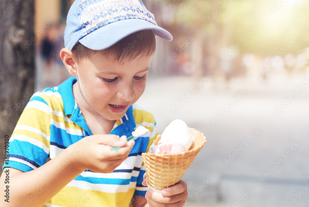 Cute European boy enjoying ice cream cone in a town street. Stock Photo ...