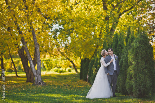 Portrait of the bride and groom strolling through the Sunny autumn fores