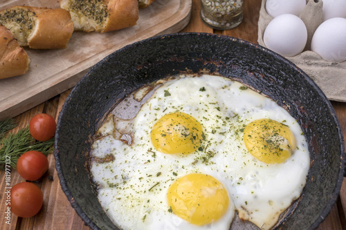 appetizing fried eggs in old frying pan