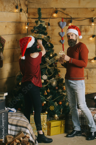 New year guy and girl decorate Christmas tree.