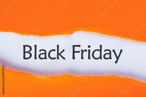 Message appearing behind ripped orange paper with Black Friday Sale text. Shopping time. Day with biggest Sale. Mockup photo