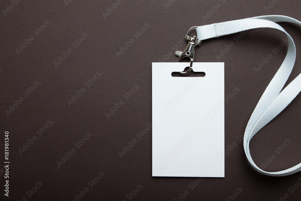 Blank badge on brown background. Blank white id card, plastic badge. Top view. Blank badge on brown background. Blank white id card, plastic badge. Top view.