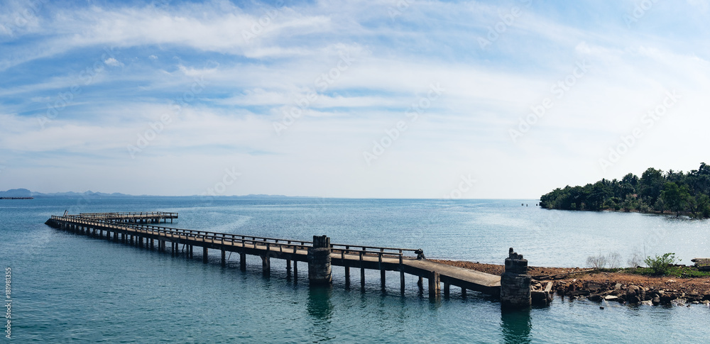 Port ferry boat with concrete ferry pier, panoramic view. Travel inspiration. Tropical landscape over sea with cloudy bright sky, Koh Chang island, Thailand.