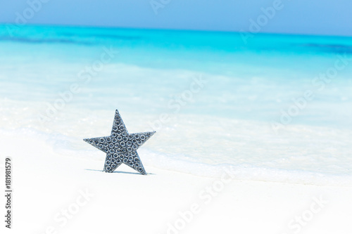 Fototapeta Naklejka Na Ścianę i Meble -  Stars decorations on sandy beach, greeting card