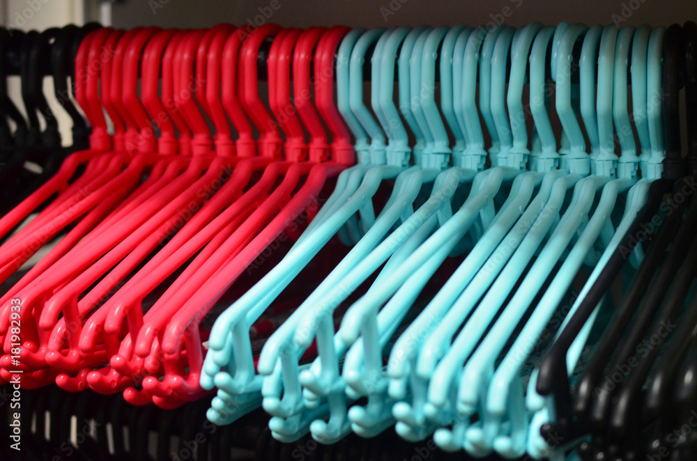 A row of empty hangers of turquoise and red flowers. A row of empty hangers of turquoise and red flowers.