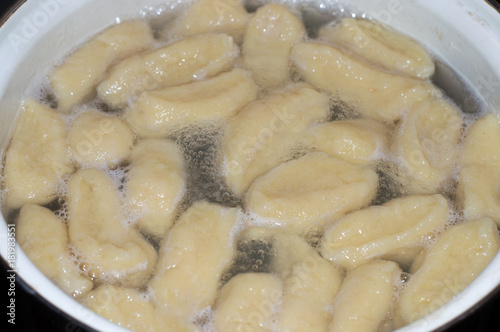 Cooking kopytka or kapytki. Polish traditional potato dumpling. photo