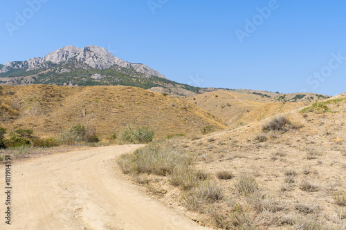 Steppe landscape with views of the rocky mountains and the road turning at an unknown distance  the Crimea  Fox Bay reserve