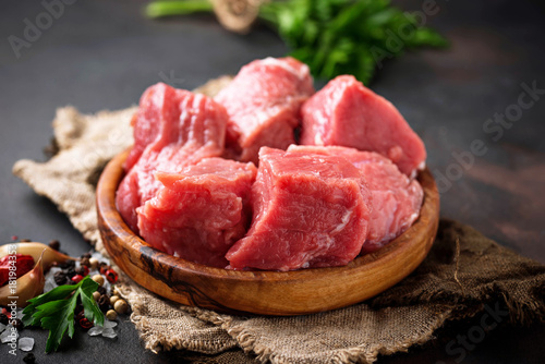 Raw chopped meat with spices on rusty background