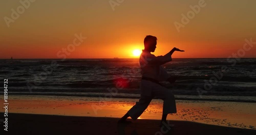 Silhouetted karate kata on the beach by a teenager photo