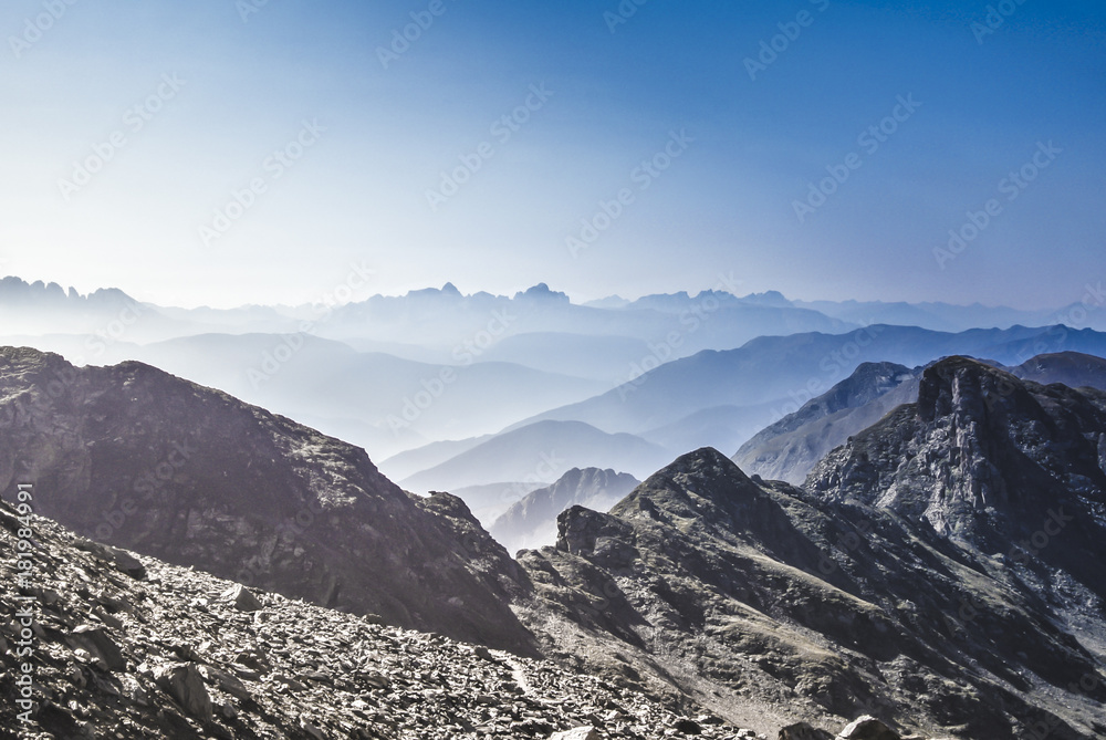 View over dusty mountains with the Dolomites on the horizon