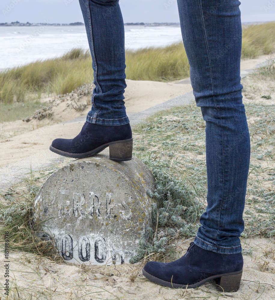 Modèle femme porte des jeans et des bottes en cuir à la plage contre la mer  Stock Photo | Adobe Stock