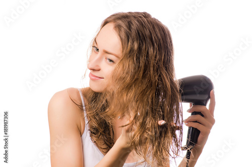 Beautiful young woman dries hair with a hairdryer beauty