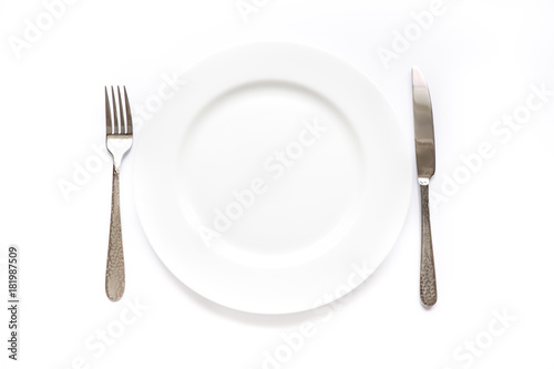 Knife, fork and plate on a white background