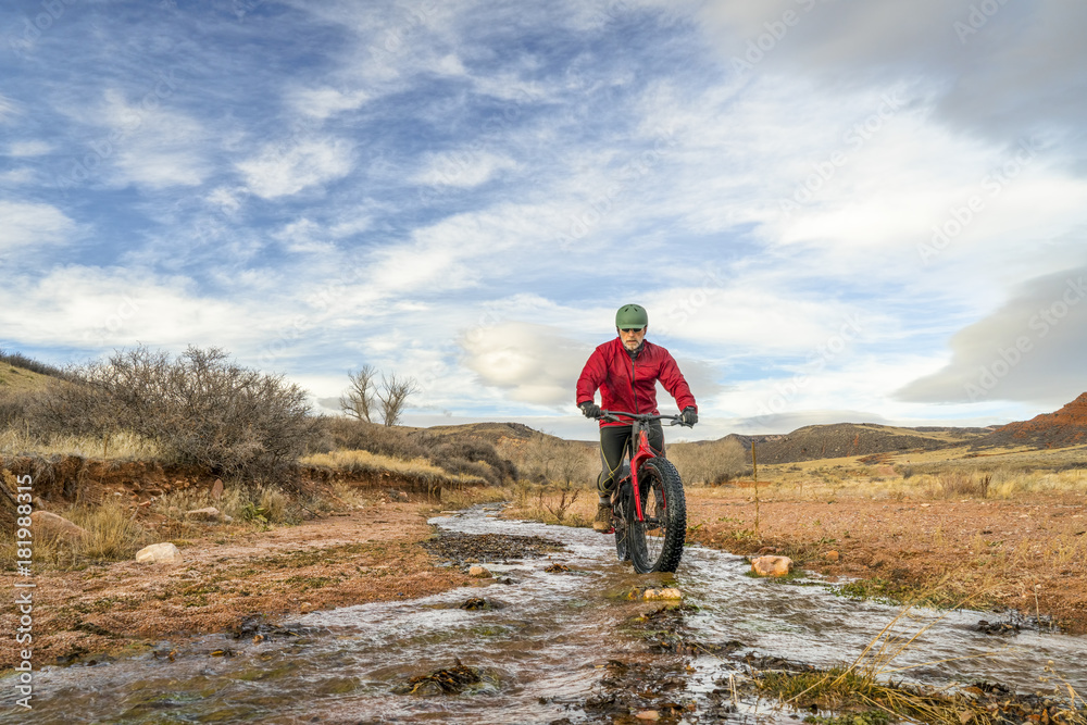 riding a fat bike across a stream