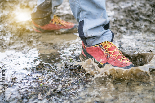 Obraz na plátně Detail of trekking boots in a mud